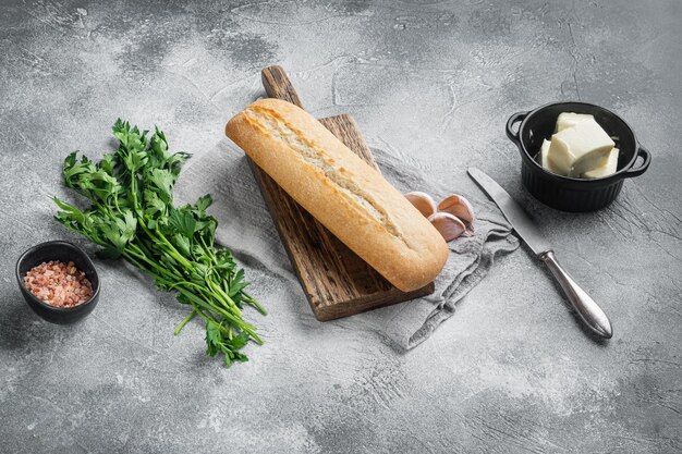 Baguette Petersilie Kräuter Butter Zutaten Set, auf grauem Steintisch Hintergrund, mit Kopierraum für Text