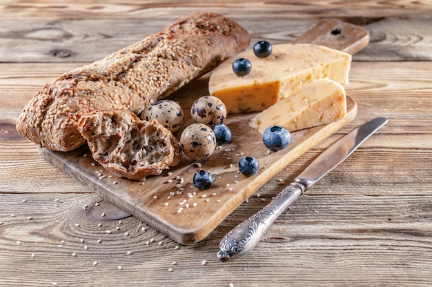 Baguette, queso con especias y hierbas, huevos de codorniz, arándanos. T