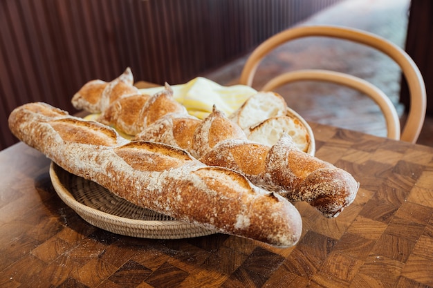 Baguette recién horneado y caliente en la canasta en mesa de madera