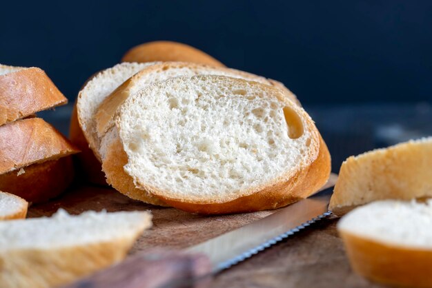 Baguette de trigo cortado en trozos en una tabla para cortar