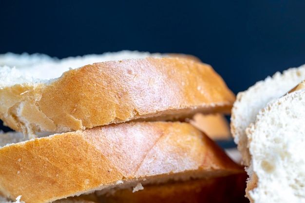 Baguette de trigo cortado en trozos en una tabla para cortar