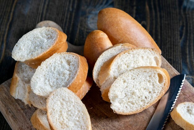 Baguette de trigo cortado en trozos en una tabla para cortar