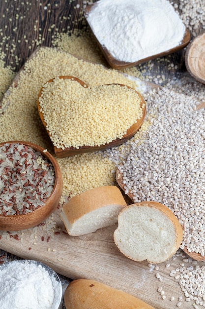 Baguette de trigo sobre la mesa con harina y varios granos vegetales