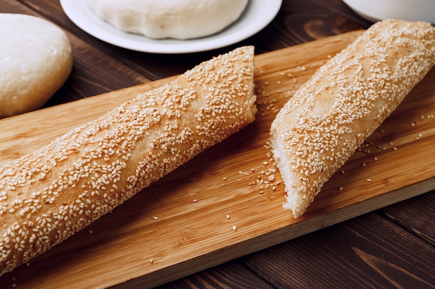 Baguettebrot auf braunem Holzbrett schließen Foto oben