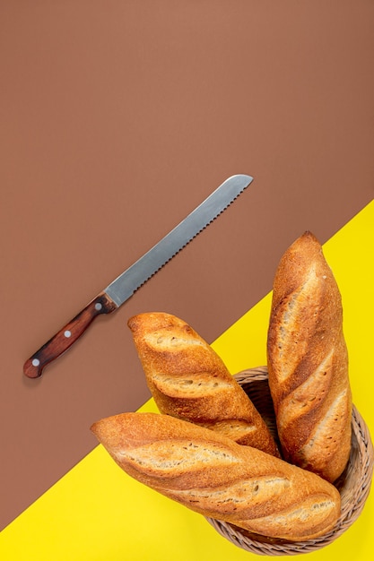 Baguettes tradicionales recién horneadas y un cuchillo de pan