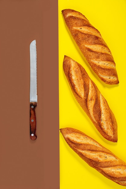 Baguettes tradicionales recién horneadas y un cuchillo de pan