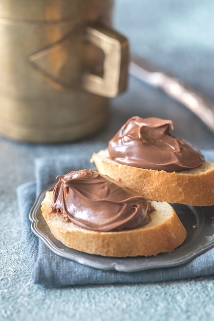 Baguettescheiben mit Schokoladencreme auf der Untertasse