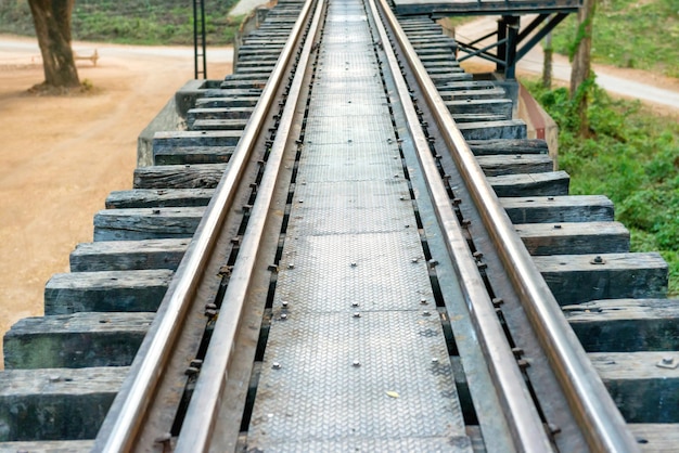 Bahnstrecke mit Holzschwellen und rostigen Schienen an der alten Eisenbahnbrücke