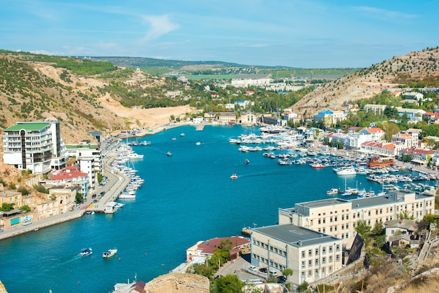 Baía de Balaklava no verão em tempo ensolarado. Crimeia, Rússia. Muitos barcos e navios. montanhas, mar. cor de água turquesa. Fortaleza genovesa de Chembalo