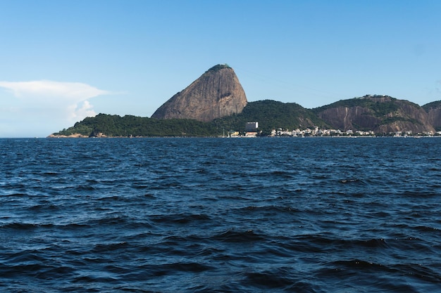 Baía de Guanabara no Rio de Janeiro Brasil com Pão de Açúcar ao fundo Bela paisagem e morro com o mar Dia ensolarado de verão