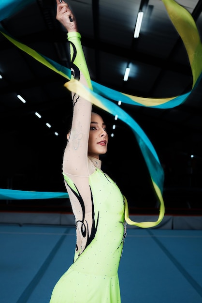 Baila de cinta y gimnasia rítmica mujer en gimnasia con acción y rendimiento para el fitness Atleta de competición y bailarina de gimnasia femenina con creatividad y rutina artística y energía en la arena