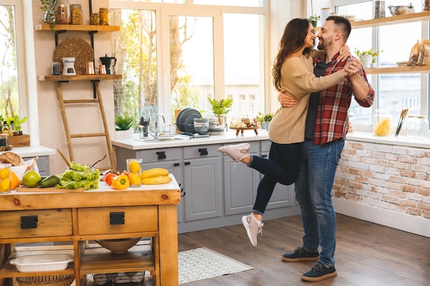 Bailando en la cocina. joven pareja romántica celebrando compromiso copia espacio. linda pareja joven bailando en casa.