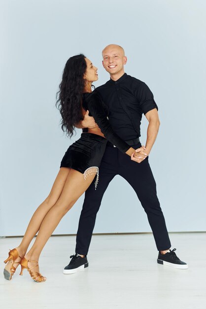 Bailando en el estudio con fondo blanco Una pareja alegre está junta en el interior