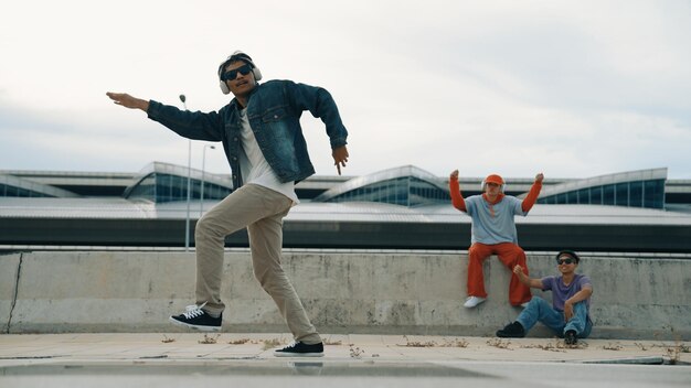 El bailarín de break disfruta realizando movimientos de estilo libre con sus amigos alentando rápidamente