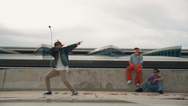 El bailarín de break disfruta realizando movimientos de estilo libre con sus amigos animando animadamente