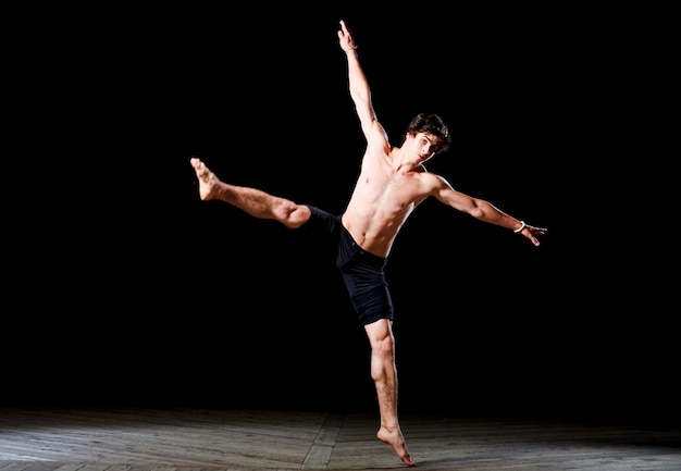 Bailarín de estilo de ballet moderno se realiza en un escenario iluminado.