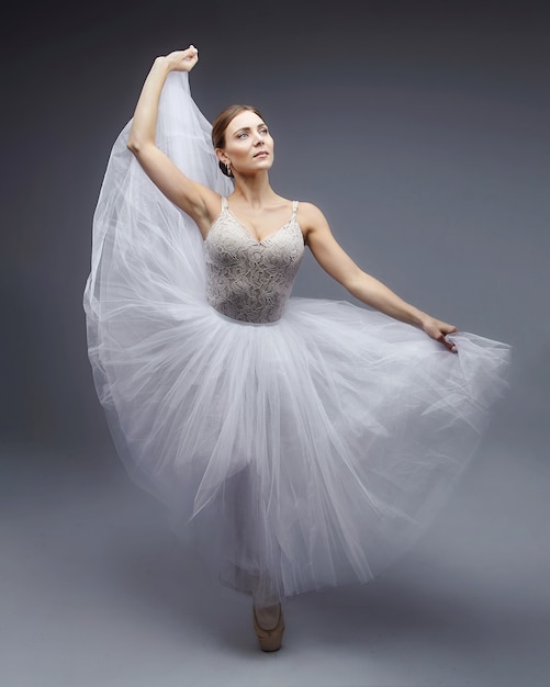 Bailarina atraente posando graciosamente em um fundo branco