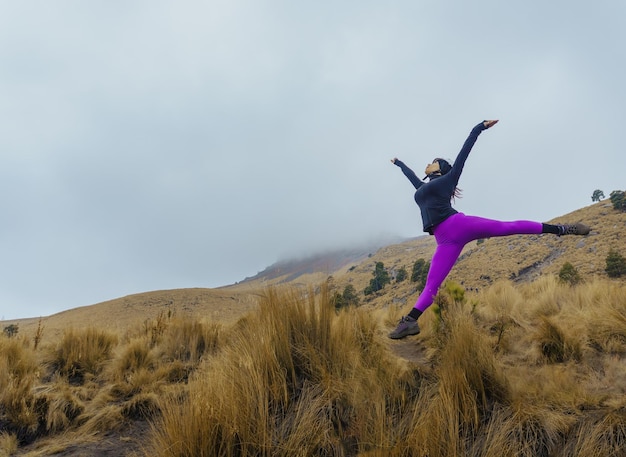 Bailarina bailando y saltando en una hermosa montaña