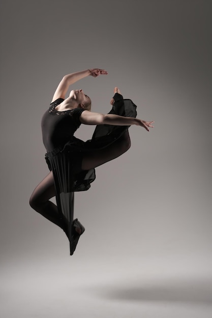 Bailarina Bailando con Tela de Seda Bailarina de Ballet Moderno en Revoloteando Fondo Gris de Tela Ondulante