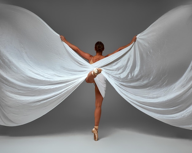 Bailarina Bailando con Tela de Seda Bailarina de Ballet Moderno en Revoloteando Zapatos de Punta de Tela Ondeando Fondo Gris