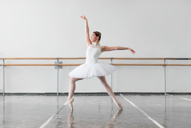 Bailarina de ballet femenino mantener el estante en clase