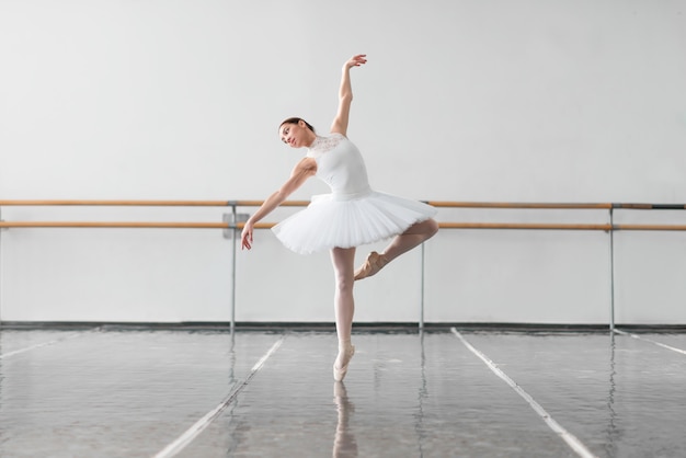 Bailarina de ballet femenino mantener el estante en clase