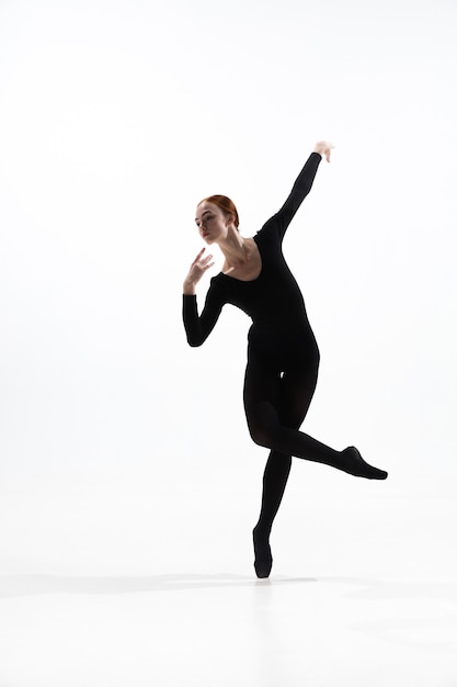 Bailarina de ballet joven y elegante en estilo negro mínimo aislado sobre fondo blanco de estudio