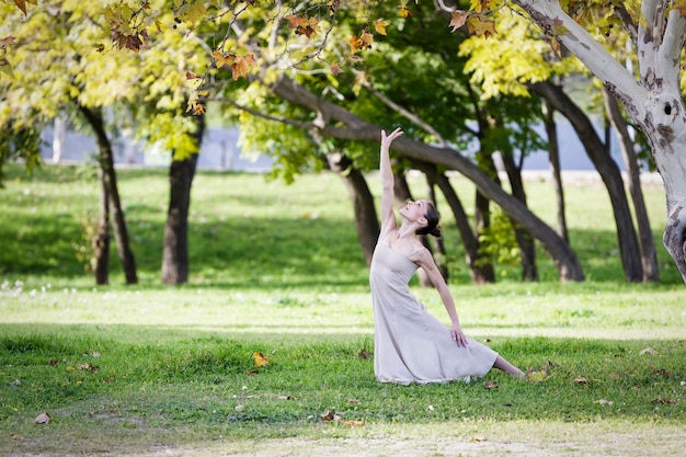 Bailarina contemporánea bailando en el parque en un día soleado