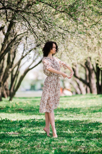 Bailarina de mulher no jardim florescendo. rosa. balé. retrato de menina dança ao ar livre. moda e estilo