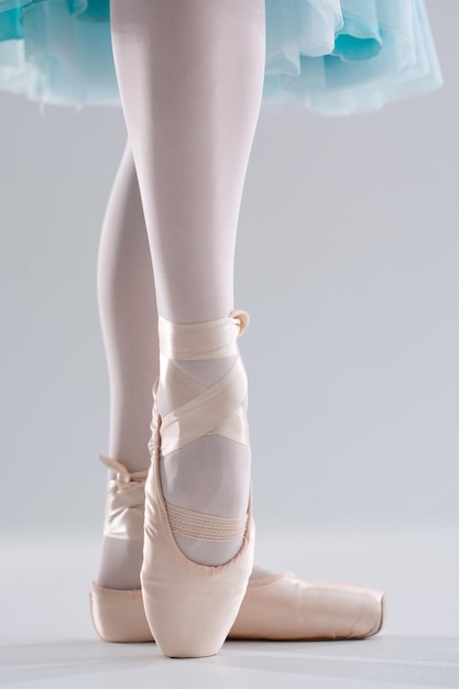 Bailarina em sapatilhas ballet posando performance pernas de mulher com sapatos para dançar balé em fundo branco