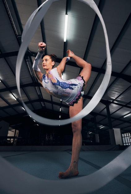 Foto bailarina y equilibrio para gimnasia de cinta en competencia deportiva o concierto en arena oscura energía de atleta flexible y estiramiento para desafío de entrenamiento ágil o ritmo en competencia