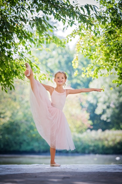 Bailarina fofa com um vestido rosa no verão ao ar livre