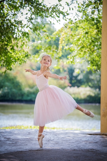 Bailarina fofa com um vestido rosa no verão ao ar livre