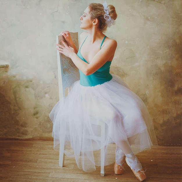 Bailarina jovem e graciosa em sapatilhas e um tutu dança no estúdio. Coreografia, dança