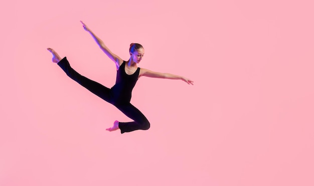 Bailarina de joven adolescente bailando sobre un fondo rojo de estudio. Ballet, danza, arte, modernidad, concepto de coreografía