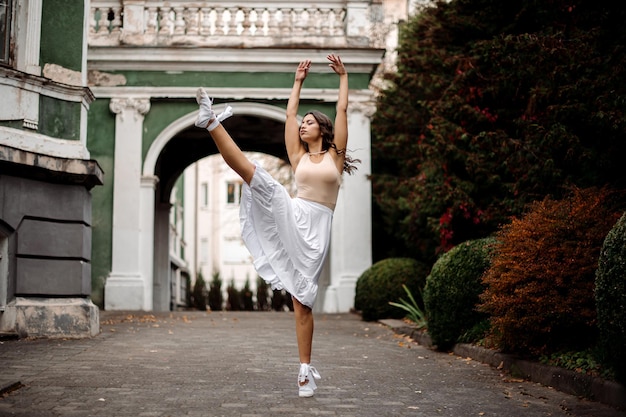 Bailarina joven está bailando al aire libre en el antiguo edificio o museo