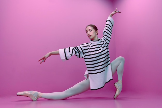 Bailarina joven en medias blancas y media falda posa pasos de ballet de pie en zapatos de punta