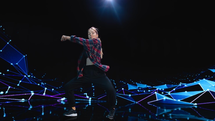 Foto bailarina profesional joven y elegante realizando una rutina de baile de hip hop frente a una gran pantalla de pared con animación vfx durante una producción virtual en un entorno de estudio 105 bpm song