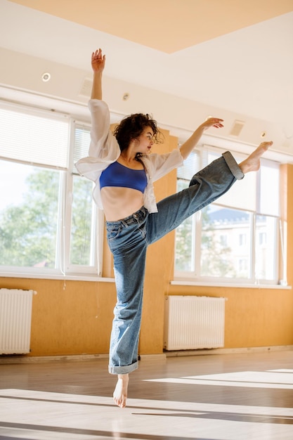 Bailarina realizando un baile y saltos en el estudio de baile