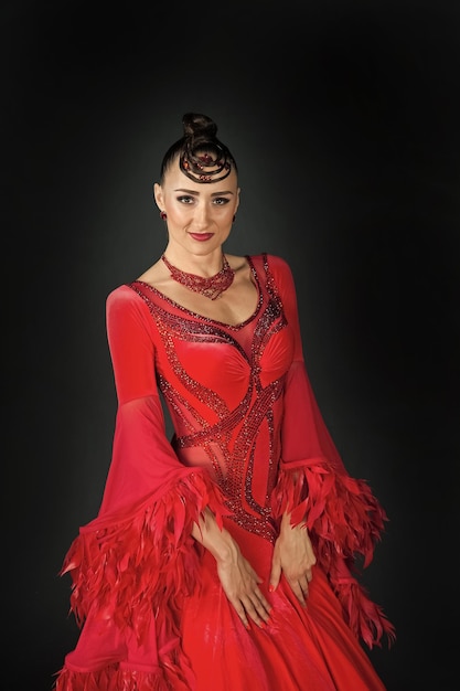 Bailarina de salón de mujer en vestido rojo sobre fondo oscuro