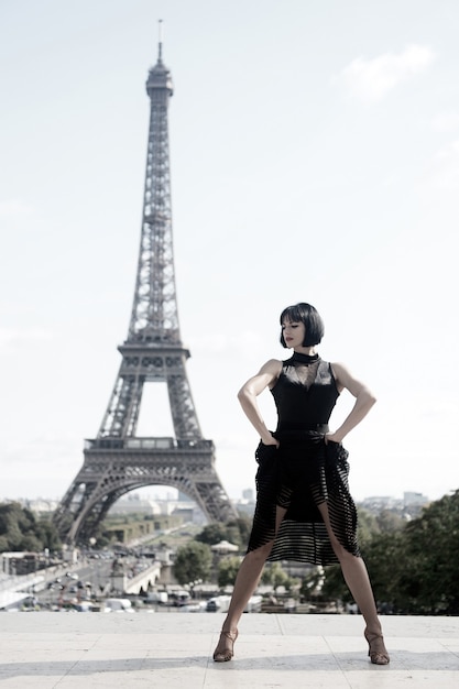 Bailarina sexy chica frente a la torre eifel en parís, francia. hermosa mujer en pose de danza como torre eifel. concepto de viaje romántico