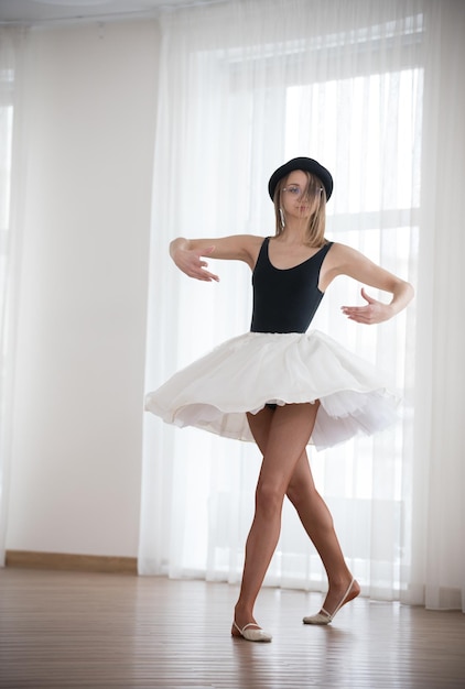 Bailarina en el sombrero está bailando en el estudio.