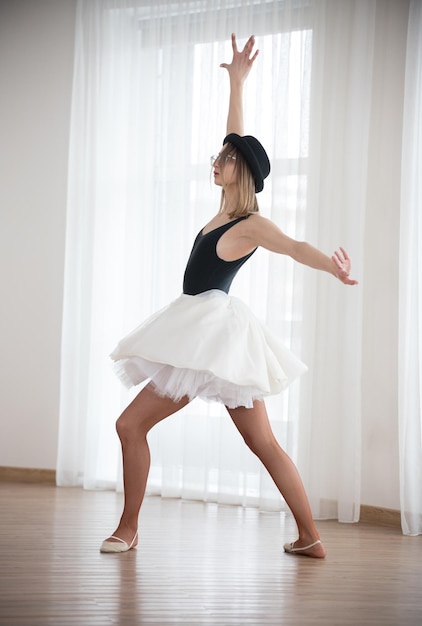 Bailarina en el sombrero está bailando en el estudio.