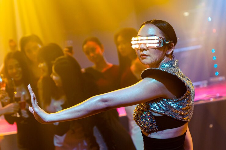 Foto bailarina de techno en club nocturno bailando al ritmo de la música de dj