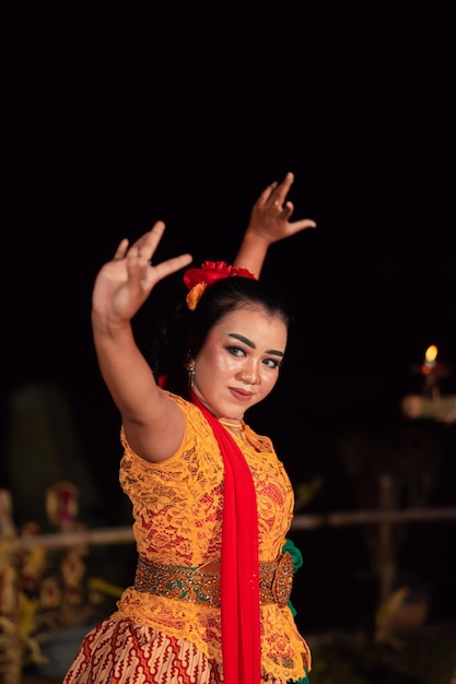 Foto una bailarina tradicional asiática con un vestido naranja con una bufanda roja y maquillaje actuando en el festival de danza