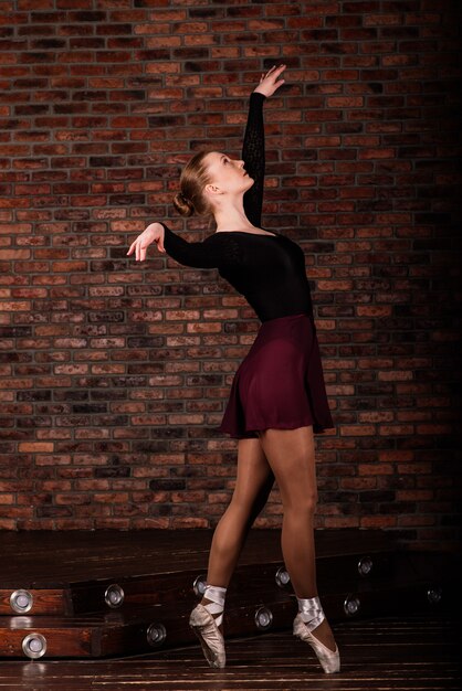 Bailarina en traje oscuro, vestido en estudio interior oscuro