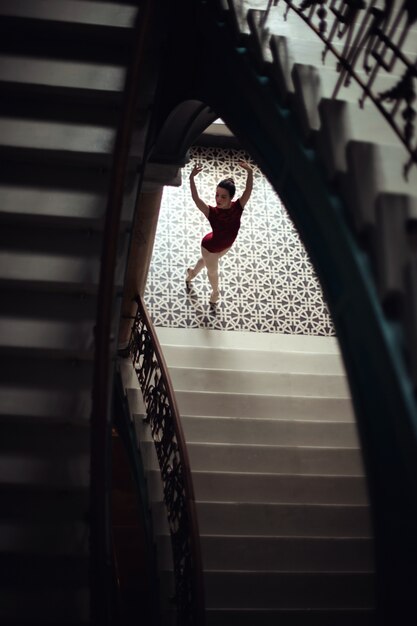 Foto bailarina con un vestido rojo vista desde unas escaleras