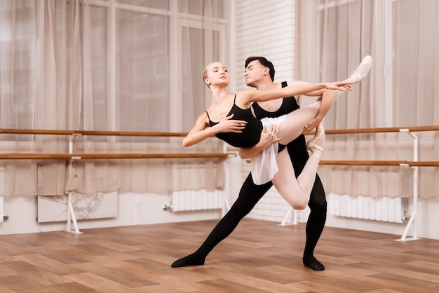 Bailarines del hombre y de la mujer que presentan en clase del ballet.