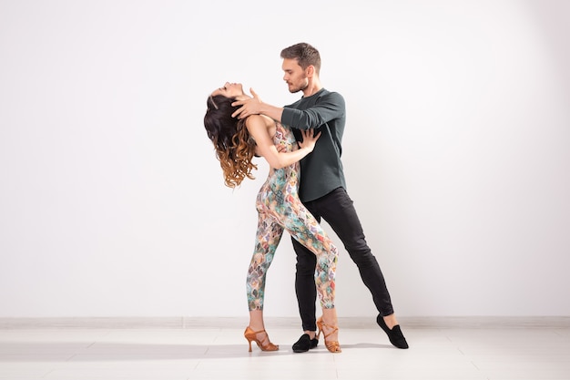 Bailarines de salsa, kizomba y bachata sobre fondo blanco con espacio de copia. Concepto de danza social