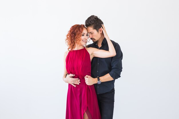 Baile social, bachata, kizomba, salsa, concepto de tango - Close up retrato de mujer hombre vestido con hermosos trajes sobre pared blanca.